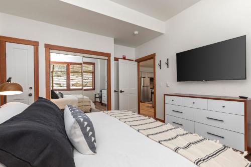 a bedroom with a large bed with a flat screen tv at Powderhorn Lodge 102: Sego Lily Suite in Solitude