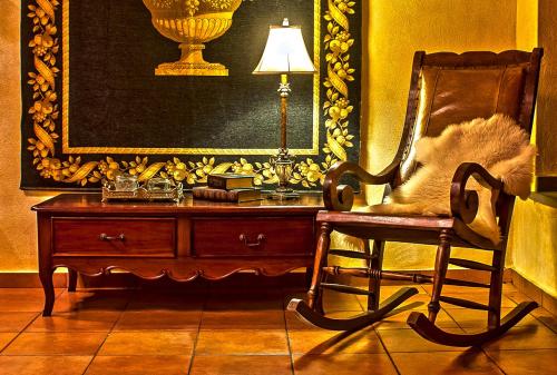 a room with a chair and a desk with a lamp at Hotel Doupiani House in Kalabaka