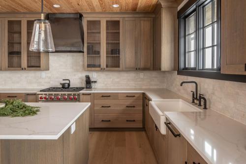 uma cozinha com armários de madeira e bancadas brancas em 86 Moose Ridge em Big Sky