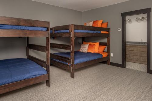 a bedroom with two bunk beds with blue and orange pillows at 86 Moose Ridge in Big Sky