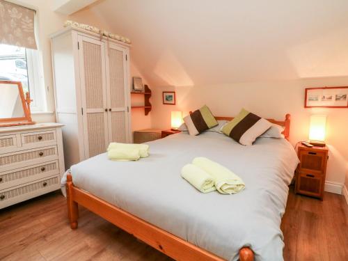 a bedroom with a large bed with white sheets at Peek A Boo in Beaworthy