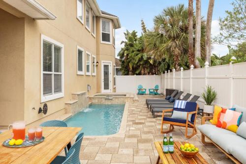 un patio trasero con piscina y una casa en Vilano Villa en St. Augustine