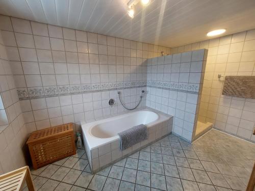 a bathroom with a bath tub in a tiled room at Allgäu Bergblick in Leutkirch im Allgäu