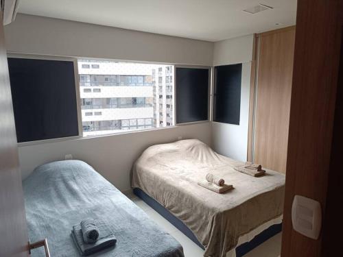 Una pequeña habitación con dos camas y una ventana. en 100 Metros do Mar - Ponta Verde, en Maceió