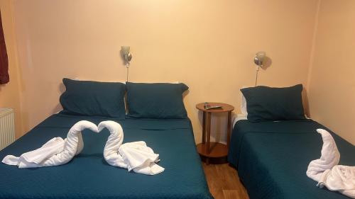 two swans made out of towels on two beds at HOSTAL VICTORIA in Punta Arenas