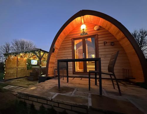 une maison en forme de dôme avec une table en face dans l'établissement Dog Friendly Glamping Pods with Hot Tubs, à Dwyran