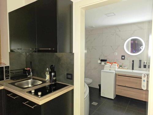 małą kuchnię ze zlewem i toaletą w obiekcie Arcobaleno Apartments & Rooms w mieście Varaždin