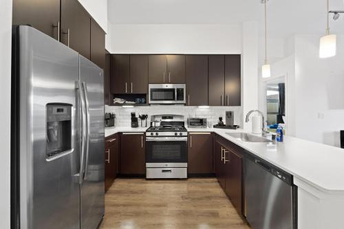 a kitchen with stainless steel appliances and wooden cabinets at San Diego Stay, Pool, Gym, Near Zoo, Petco Park & SeaWorld in San Diego