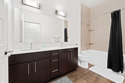 a bathroom with a sink and a tub and a toilet at Pineapple Haven in San Diego