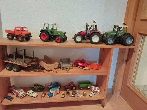 a group of toy trucks and tractors on a shelf at Allgäu Bergblick in Leutkirch im Allgäu
