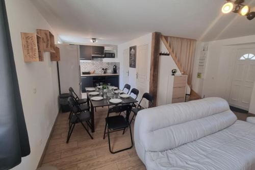 a living room with a white couch and a table and chairs at La Grange in Gasny