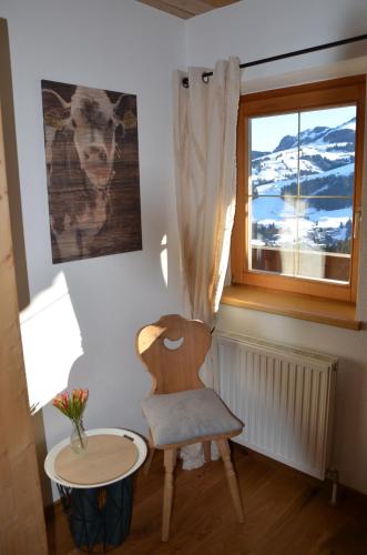a chair and a table in a room with a window at Bergbauernhof Obergaisberg in Kirchberg in Tirol