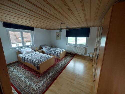 a room with two beds and a rug at Allgäu Bergblick in Leutkirch im Allgäu
