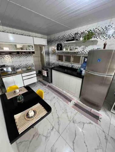 a kitchen with a table and a refrigerator in it at Aconchegante e charmosa in Penedo