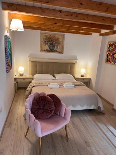カリアリにあるAffittacamere Louisのベッドルーム1室(大型ベッド1台、ピンクの椅子付)