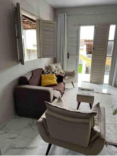 a living room with a couch and chairs in it at Aconchegante e charmosa in Penedo