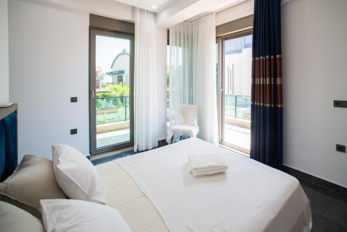 a bedroom with a white bed and a large window at Living Dream Villa HARMONY in Belek