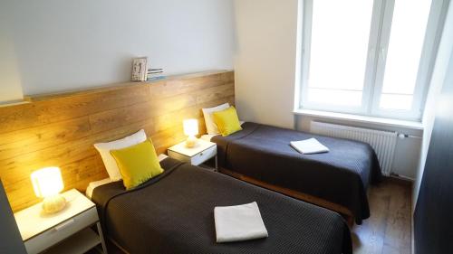 mały pokój z 2 łóżkami i 2 lampami w obiekcie Apartament Akali w Kielcach