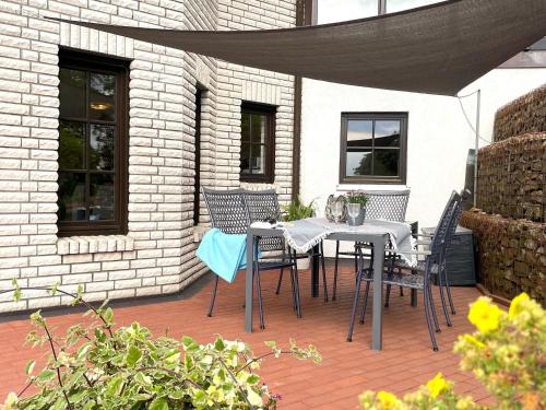 a patio with a table and chairs on a patio at Garden view Apartment in Sauerland with Terrace in Madfeld