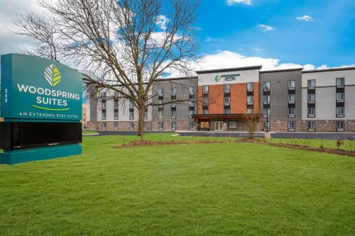 a building with a sign in front of a yard at WoodSpring Suites Dearborn Detroit in Dearborn