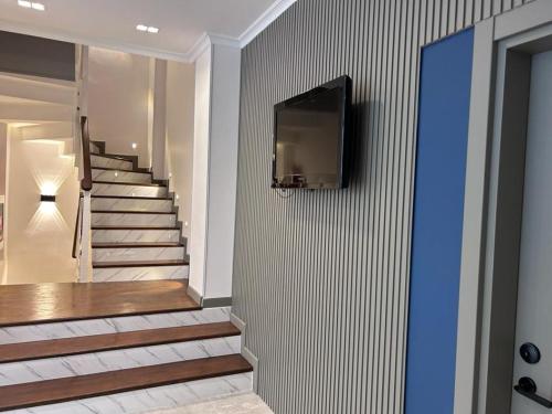 a hallway with stairs with a television on a wall at Pendik Marine Hotel in Istanbul
