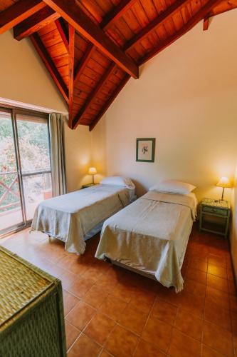 two beds in a room with a large window at Hotel Apartur Mar del Plata in Mar del Plata