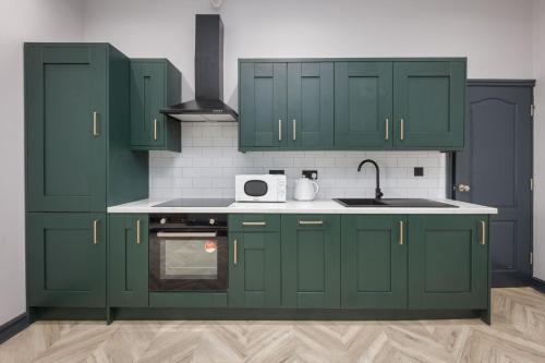 a kitchen with green cabinets and a sink at GiGi's in Blackpool