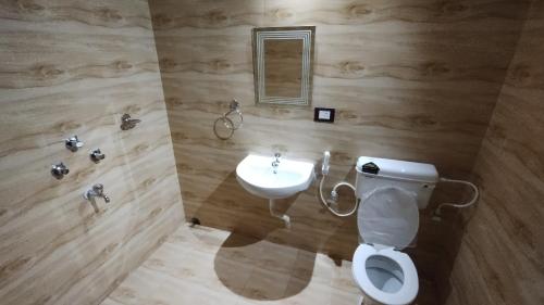 a bathroom with a white toilet and a sink at Bequest Stays Celebration in Puri