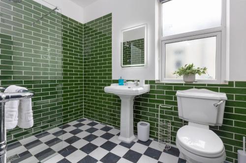 ein grün gefliestes Bad mit einem WC und einem Waschbecken in der Unterkunft GiGi's in Blackpool