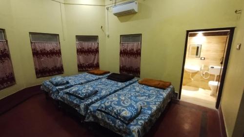 a bedroom with a bed in a room with a bathroom at Bequest Stays Celebration in Puri