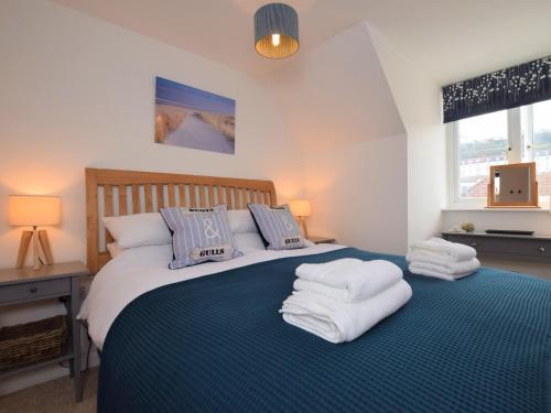 een slaapkamer met een groot bed en handdoeken bij 3 Bed in Westward Ho 74354 in Westward Ho