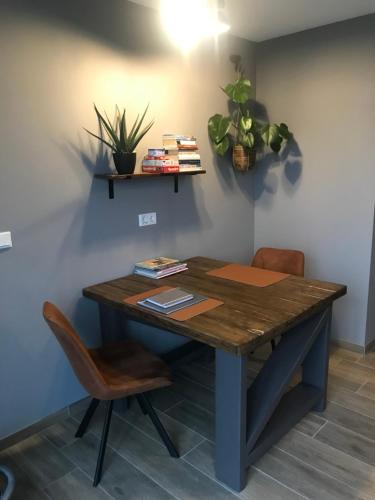 a wooden table with chairs and plants on a wall at Appartement in Meliskerke