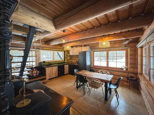 - une salle à manger avec une table et des chaises dans une cabine dans l'établissement River House, à Nītaure