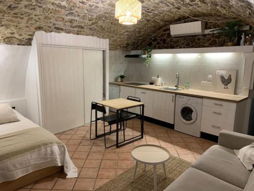 a kitchen and a living room with a bed and a table at Studio Perle de Menton in Menton