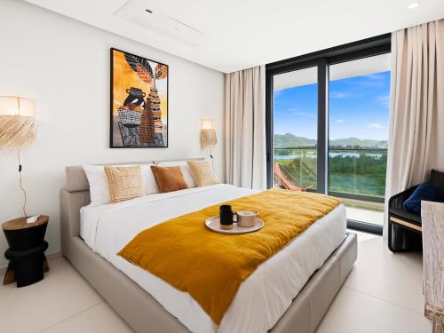 a bedroom with a large bed and a large window at Fourteen at Mullet Bay in Cupecoy