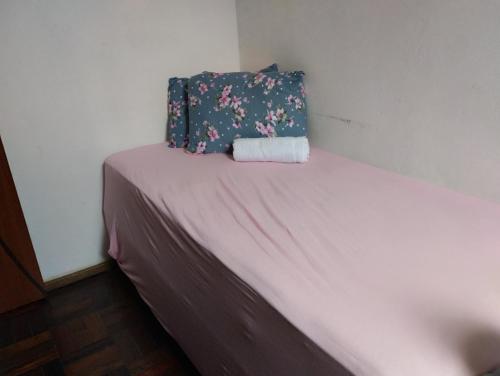 Una cama pequeña con una almohada encima. en Apartamento 2 quartos en Pelotas