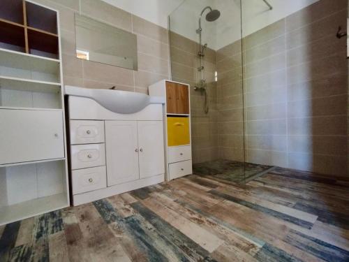 ein Badezimmer mit weißen Schränken und einem Waschbecken in der Unterkunft Villa BABYLAS in Sainte-Anne