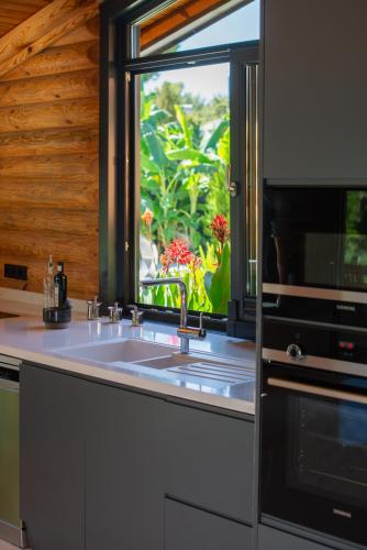 a kitchen with a sink and a window at Living Dream Villa LIGNUM in Duacı