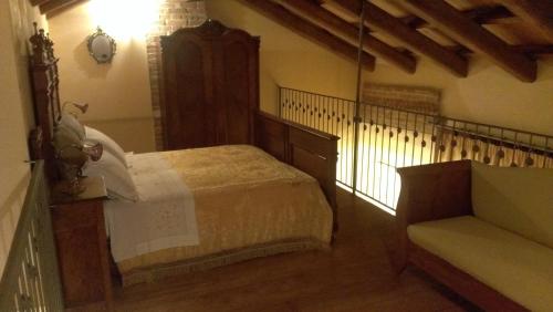 - une chambre avec un lit et un canapé dans l'établissement Agriturismo ErcolAna, à Neviglie