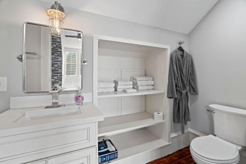 a white bathroom with a sink and a toilet at Historic Galveston Family Beach Home With 3 King Beds in Galveston