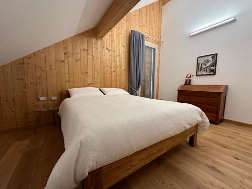 um quarto com uma cama grande e uma parede de madeira em Nido di Laura em Santa Maria Maggiore