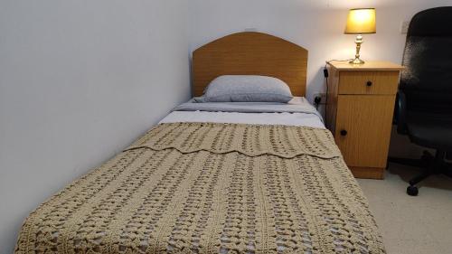 Dormitorio pequeño con cama con cabecero de madera en Your room, en St Paul's Bay