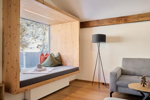 een kamer met een raam met een bed en een stoel bij Appartement Emma in Eben im Pongau
