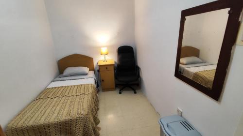 Habitación pequeña con 2 camas y espejo. en Your room, en St Paul's Bay