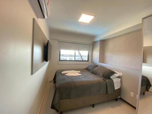 a small bedroom with a bed and a window at Cupe Beach Living Concept 304E in Porto De Galinhas