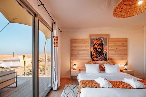 a bedroom with a bed with a picture on the wall at Inara Camp in El Karia