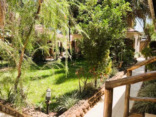 a garden with a fence and a house at Home Feeling Neneu Lodge in Moshi