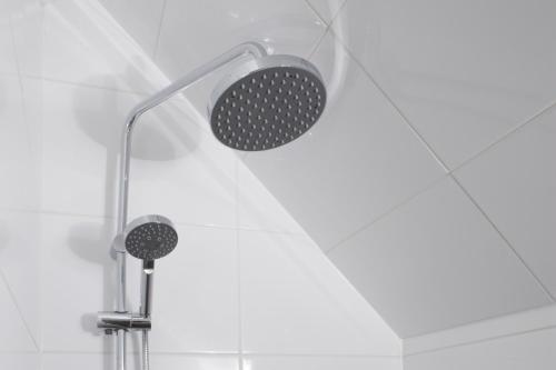 a shower with a shower head in a bathroom at Logement de Kaap in Terheijl