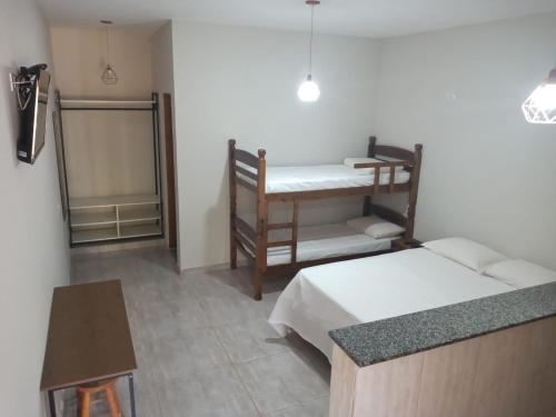Zimmer mit 2 Betten, einem Schreibtisch und einem Tisch in der Unterkunft Encantos de Canedos in Piracaia