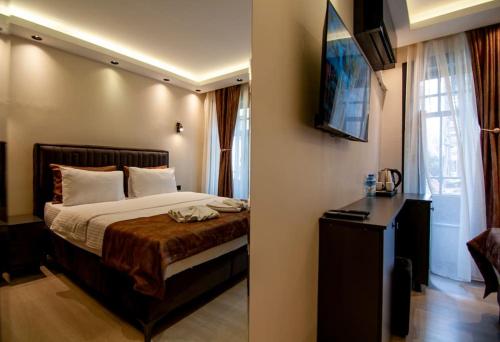 a hotel room with a bed and a television at Cozy Stay with a Turkish bath,in heart of AyaSofia in Istanbul